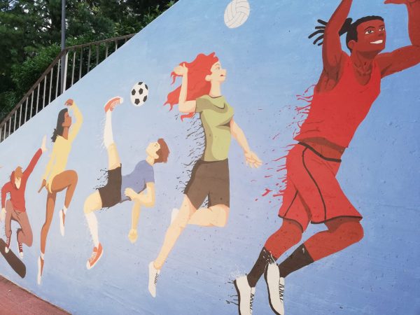 Un murale al campo sportivo, opera di due artiste studentesse
